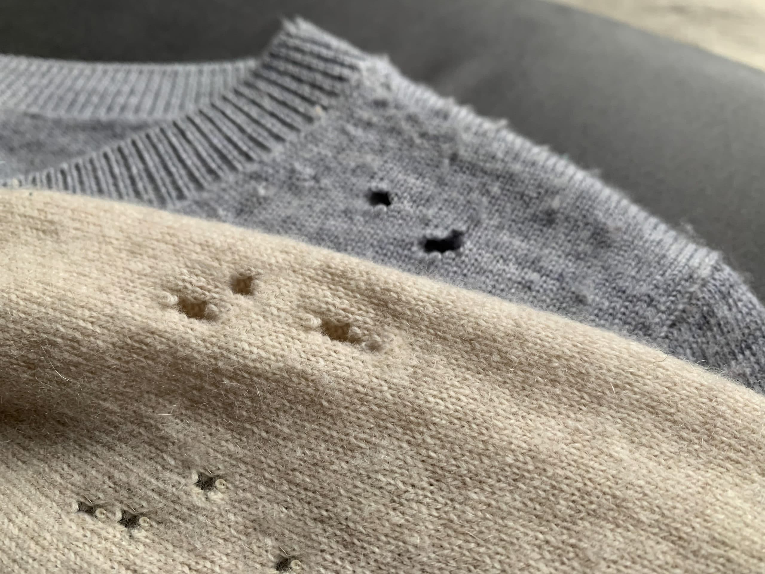 Two expensive cashmere sweaters with holes and damaged, caused by clothes moths